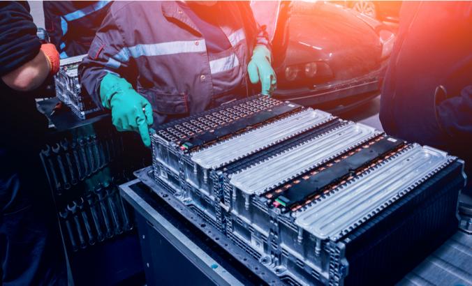 Person disassembling the battery of an electric vehicle engine.