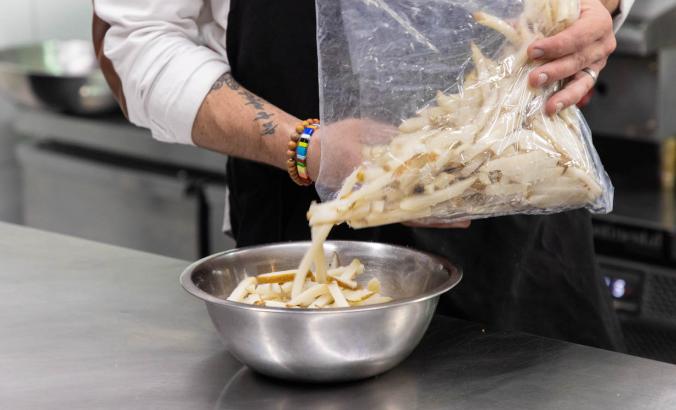 Man pours fries into a bowl 